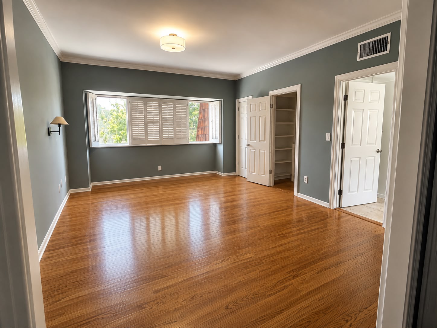 Fully remodeled bedroom with refinished hardwood floors and crown molding — Los Angeles