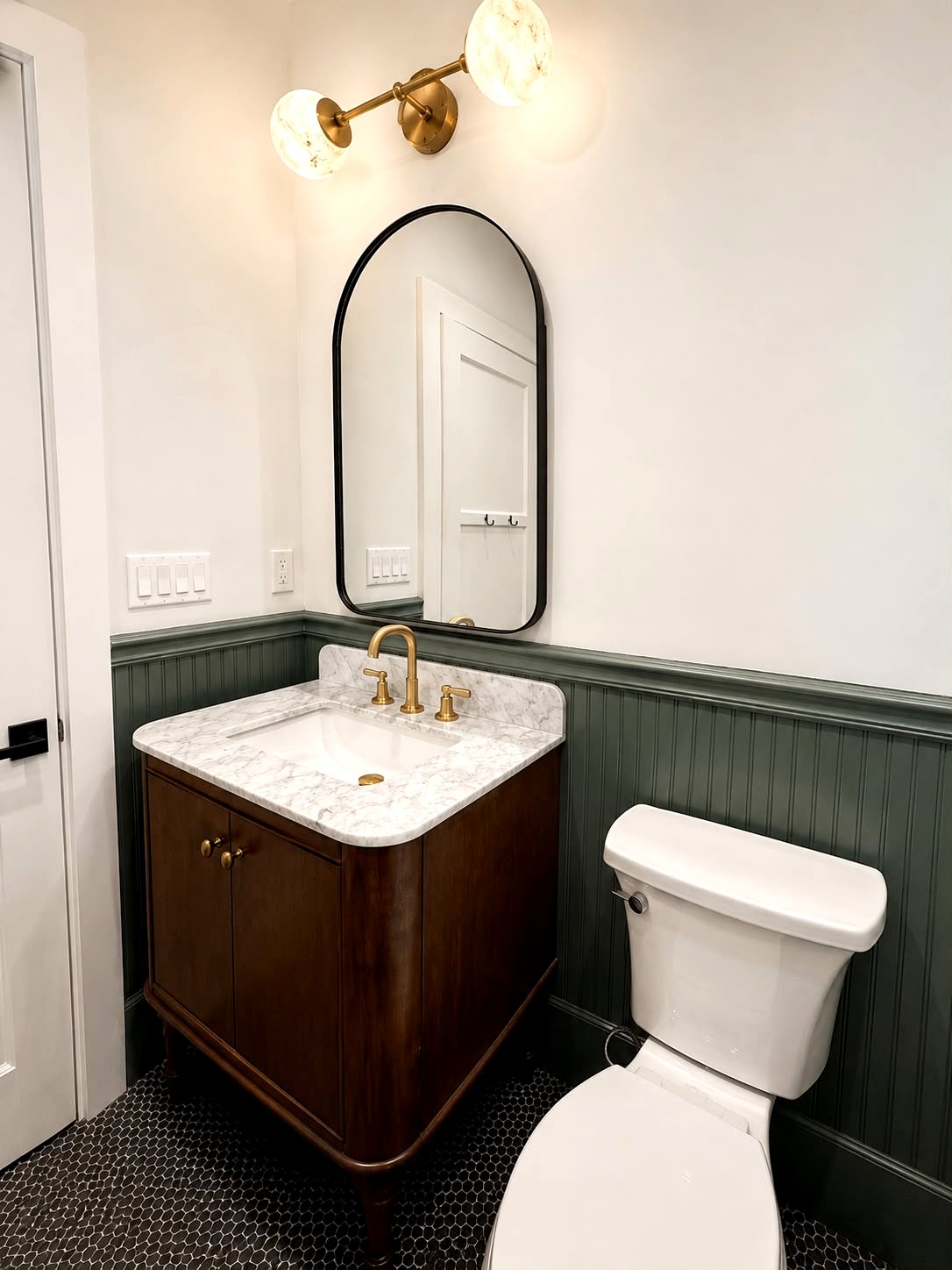 Remodeled powder room with dark wood vanity, brass fixtures and hex tile floor — Los Angeles